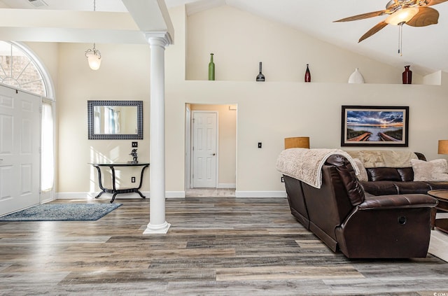 living room with ceiling fan, hardwood / wood-style floors, high vaulted ceiling, and decorative columns