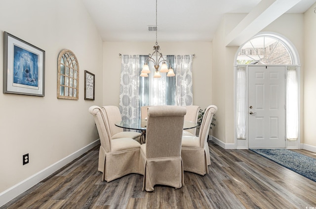 dining area featuring dark hardwood / wood-style flooring and an inviting chandelier