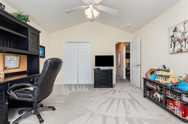 carpeted office space with ceiling fan, vaulted ceiling, and a textured ceiling