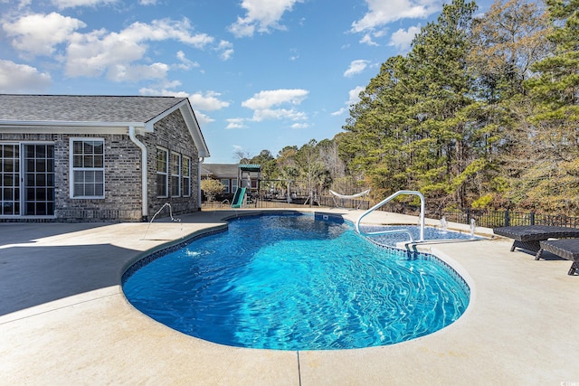 view of swimming pool featuring a playground and a patio area