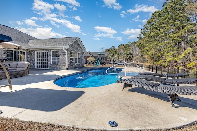 view of pool featuring a playground and a patio