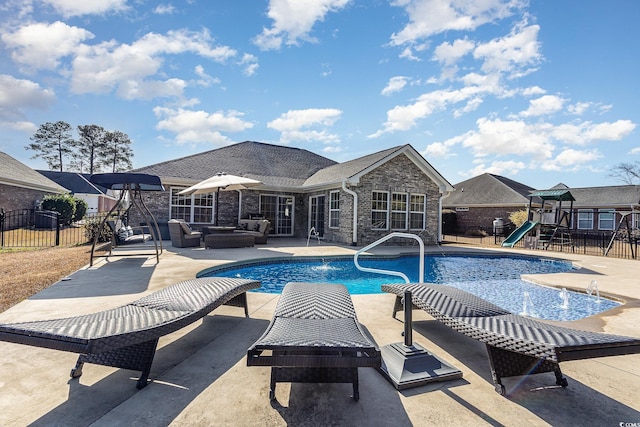 view of swimming pool with a playground, outdoor lounge area, a water slide, and a patio area