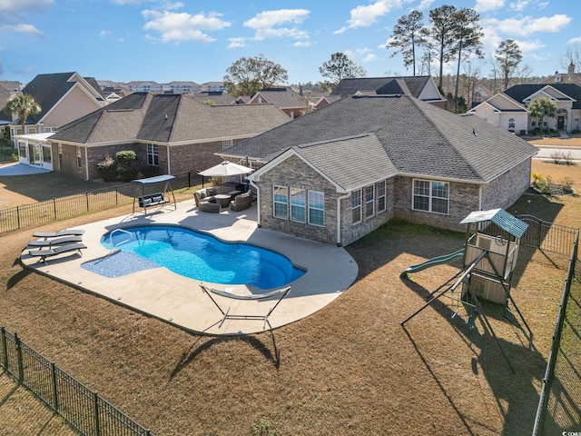 view of swimming pool with a lawn, an outdoor living space, a patio area, and a playground