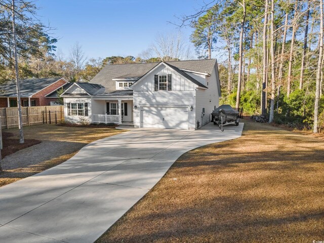 view of front of property with a front lawn, covered porch, and a garage