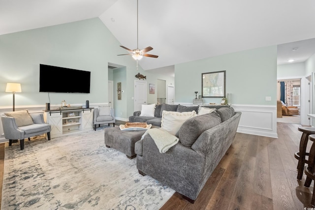 living room with ceiling fan, dark hardwood / wood-style floors, and high vaulted ceiling