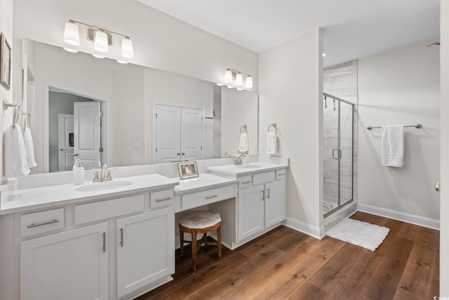 bathroom featuring vanity, wood-type flooring, and a shower with door