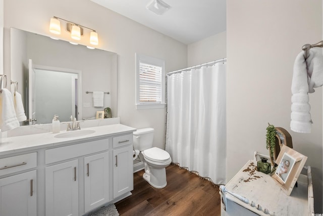 bathroom with toilet, vanity, and hardwood / wood-style flooring