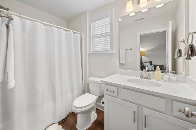 bathroom with hardwood / wood-style flooring, toilet, vanity, and a shower with shower curtain