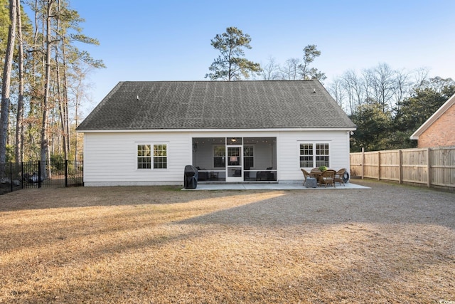 back of property with a yard and a patio