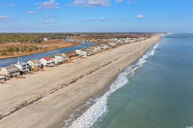 birds eye view of property with a water view and a beach view