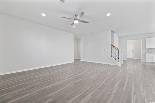 unfurnished living room featuring ceiling fan and light wood-type flooring