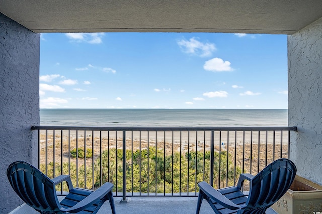 balcony featuring a view of the beach and a water view