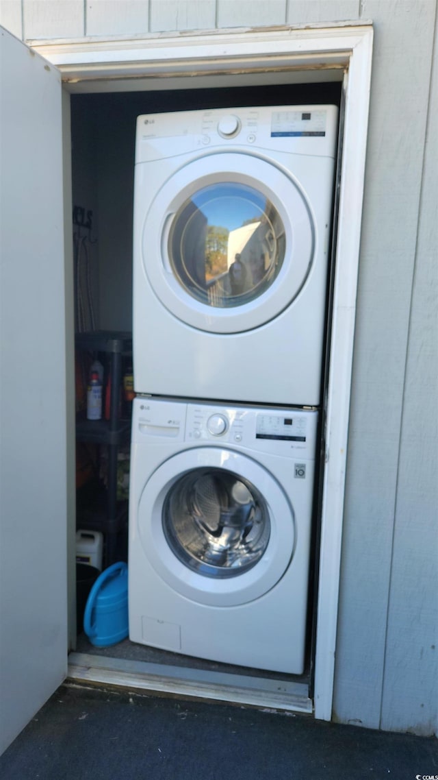 clothes washing area with stacked washer and clothes dryer