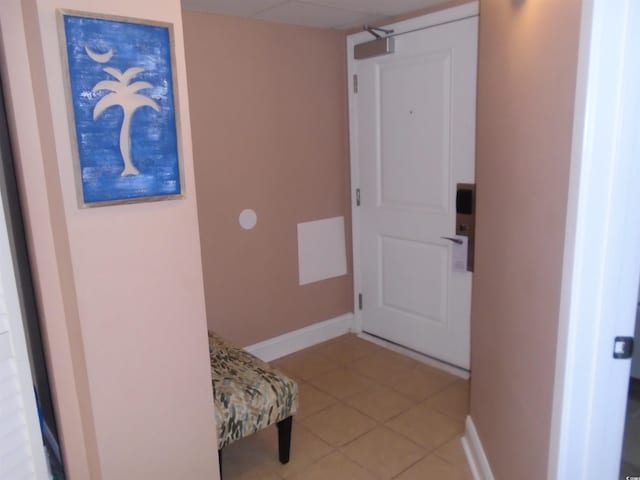 corridor featuring light tile patterned floors and baseboards