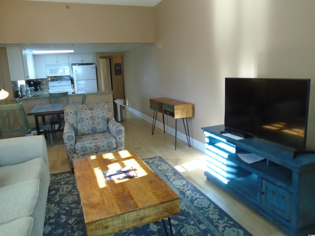 living area featuring light tile patterned floors and baseboards