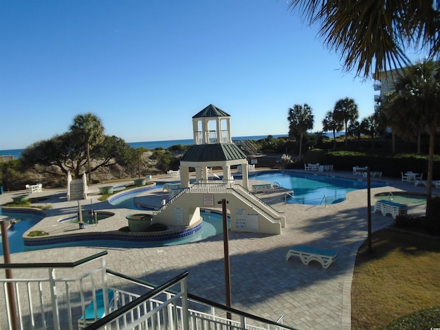 view of jungle gym featuring a patio, a jacuzzi, a community pool, and a gazebo