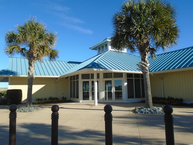 exterior space featuring a standing seam roof, metal roof, and french doors