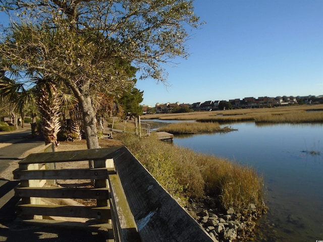 exterior space with a water view and fence