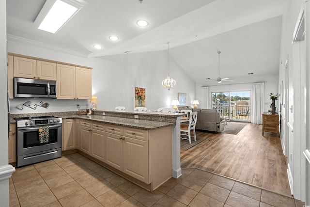 kitchen featuring light tile patterned floors, kitchen peninsula, ceiling fan with notable chandelier, and stainless steel appliances