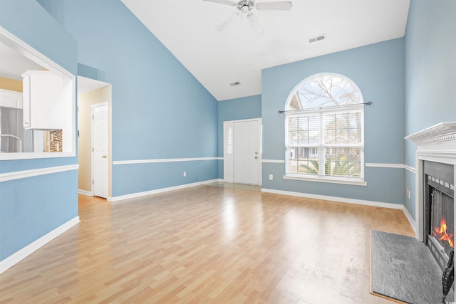 unfurnished living room featuring ceiling fan, high vaulted ceiling, and light hardwood / wood-style floors