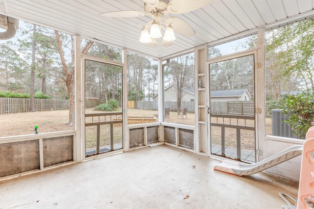 unfurnished sunroom with ceiling fan