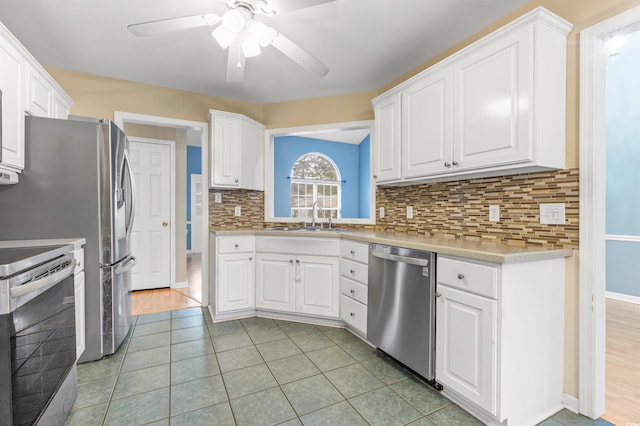 kitchen featuring light tile patterned floors, white cabinets, and stainless steel appliances