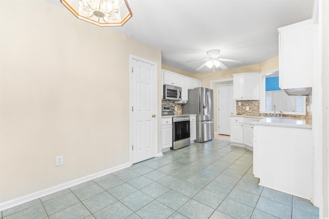 kitchen with backsplash, sink, light tile patterned floors, stainless steel appliances, and white cabinets