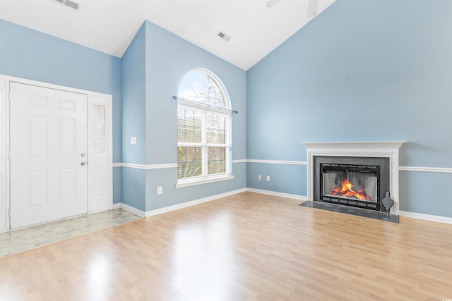 unfurnished living room with lofted ceiling, ceiling fan, and light hardwood / wood-style flooring