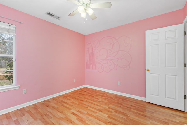 spare room featuring light hardwood / wood-style floors, ceiling fan, and a healthy amount of sunlight