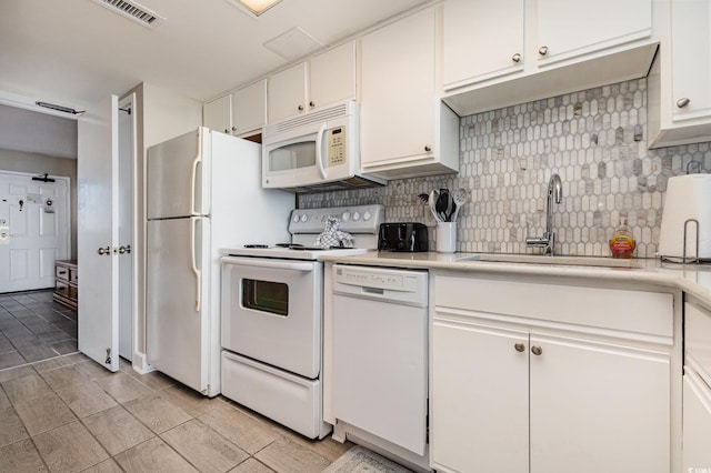 kitchen featuring white appliances, white cabinetry, sink, backsplash, and light tile patterned floors