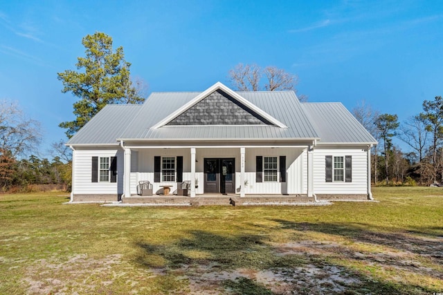 rear view of property featuring a lawn and a porch