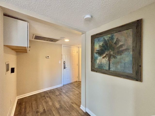 hallway with hardwood / wood-style flooring and a textured ceiling