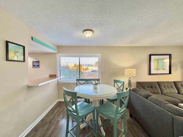 dining space with a textured ceiling and dark hardwood / wood-style floors