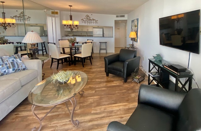 living room with light hardwood / wood-style flooring and an inviting chandelier