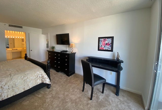 bedroom featuring light carpet, a textured ceiling, and connected bathroom