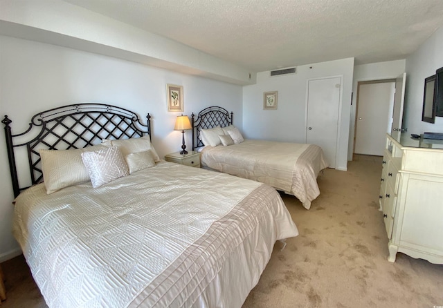 bedroom featuring light carpet and a textured ceiling