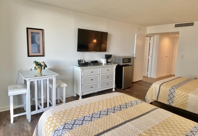 bedroom featuring dark hardwood / wood-style flooring and refrigerator