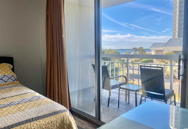 bedroom featuring hardwood / wood-style flooring and a water view