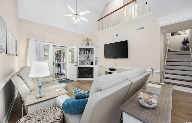 living room featuring light hardwood / wood-style floors, ceiling fan, and a high ceiling