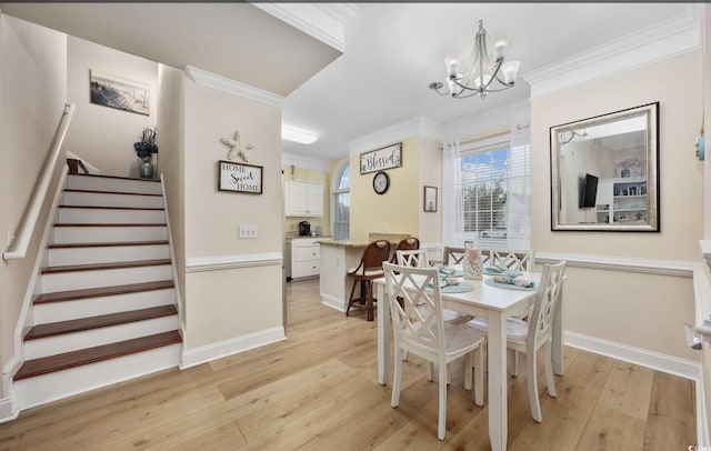 dining room with crown molding, an inviting chandelier, and light hardwood / wood-style floors