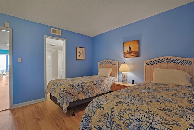 bedroom with wood-type flooring and a textured ceiling