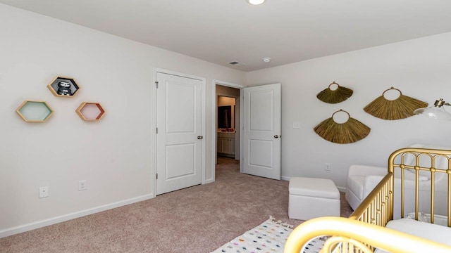 bedroom featuring light carpet and a crib