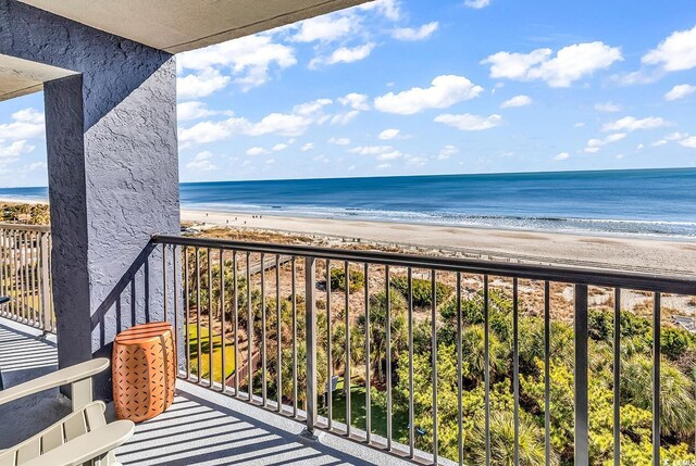 balcony featuring a water view and a view of the beach