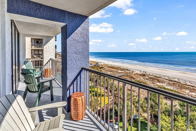 balcony with a water view and a beach view