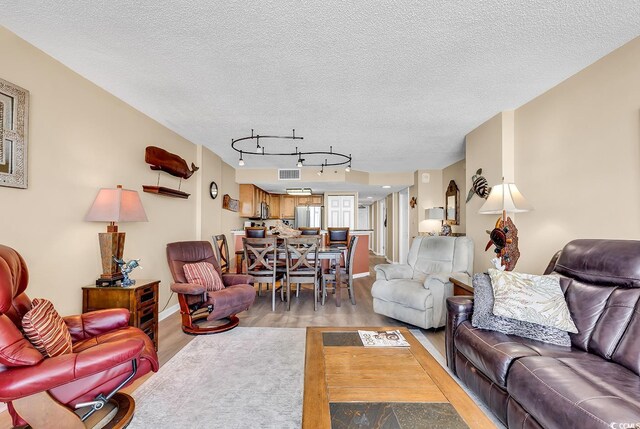 kitchen featuring light hardwood / wood-style floors, rail lighting, stainless steel appliances, and a breakfast bar area