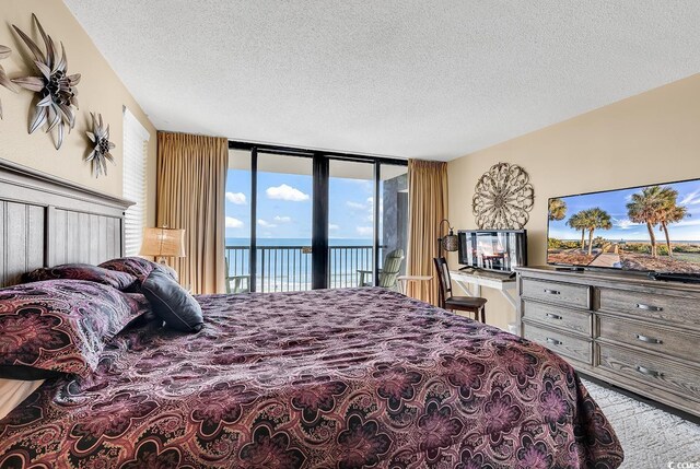 balcony featuring a view of the beach and a water view