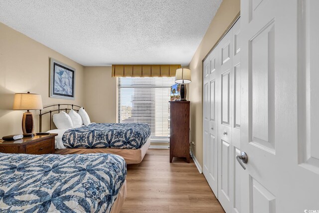 bedroom featuring a textured ceiling, a closet, and light wood-type flooring