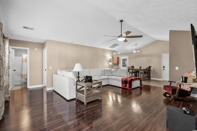 living room featuring vaulted ceiling, dark hardwood / wood-style flooring, and ceiling fan with notable chandelier