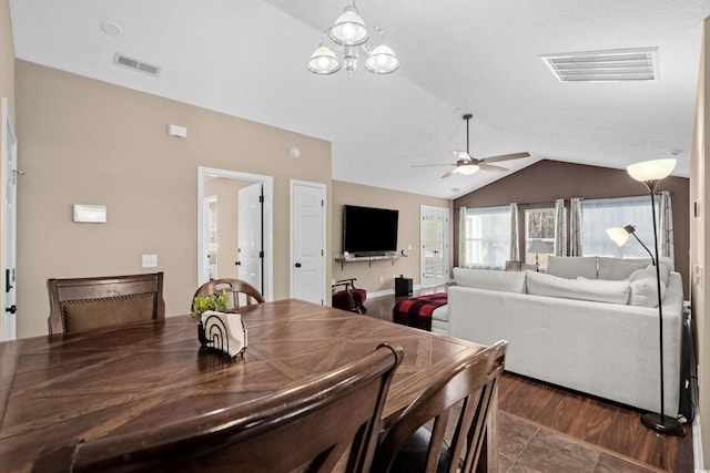 dining room with ceiling fan with notable chandelier and lofted ceiling