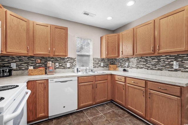 kitchen featuring light brown cabinetry, sink, tasteful backsplash, and white appliances